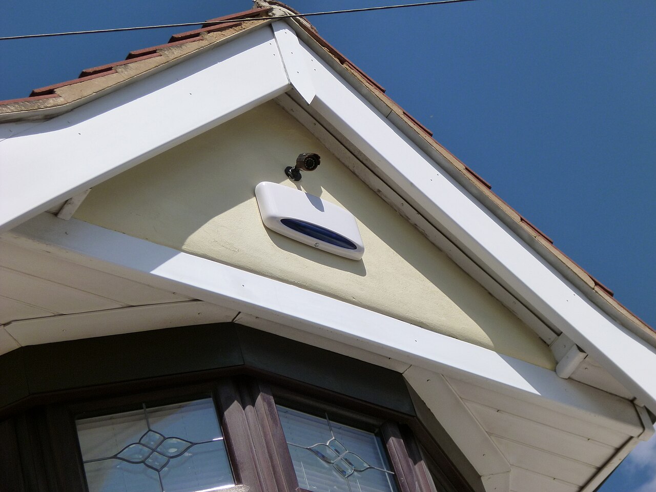 External intruder alarm sounder and a small camera on a house.
